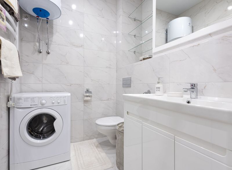 Plumber installing a bathroom sink fixture in a Denver home